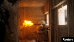 Free Syrian Army fighters take cover while firing a rocket on the front line in Izaa district in Aleppo Feb. 24, 2013. 
