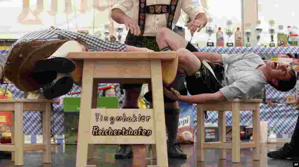 A judge watches the leather ring held by two competitors with their middle fingers at the Alps Finger Wrestling championships in Reichertshofen, southern Germany. Competitors battle for the title in this traditional rural sport where the winner has to pull his opponent over a marked line on the table.