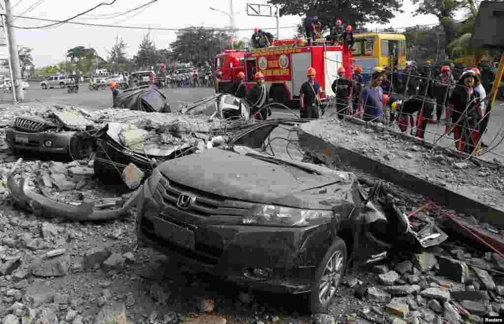 Los bomberos participan de las tareas de rescate junto a vehículos destrozados por el terremoto en la ciudad de Cebú, en la región central de Filipinas, este martes 15 de octubre de 2013. 