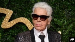 FILE - Karl Lagerfeld poses for photographers upon arrival at the British Fashion Awards 2015 in London.