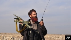 An Afghan militia man stands guard in the Achin district of Nangarhar province, east of Kabul, Afghanistan, Dec. 27, 2015. 