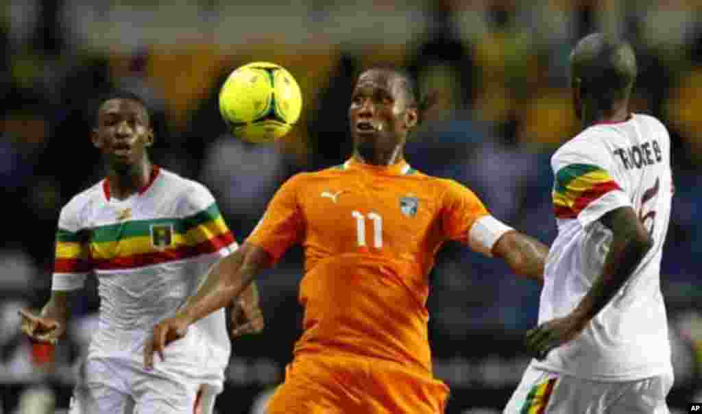 Ivory Coast's Didier Drogba (C) controls the ball between two Mali players during their African Nations Cup semi-final soccer match at the Stade De L'Amitie Stadium in Gabon's capital Libreville February 8, 2012.