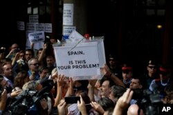 Pro-independence protestors hold up a fake ballot box as they gather outside the headquarters of the region's department of economic affairs in Barcelona, Spain, Sept. 20, 2017.