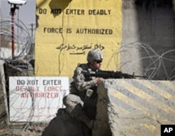 A US soldier controls the area outside the gate of a US base after an attack in Kabul, Afghanistan, April 2, 2011