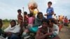 Exhausted Rohingya refugees wait to be taken to a refugee camp after crossing the Naf river at the Bangladesh-Myanmar border in Palang Khali, near Cox’s Bazar, Bangladesh, Nov. 2, 2017.