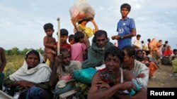 Exhausted Rohingya refugees wait to be taken to a refugee camp after crossing the Naf river at the Bangladesh-Myanmar border in Palang Khali, near Cox’s Bazar, Bangladesh, Nov. 2, 2017.