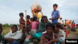 Exhausted Rohingya refugees wait to be taken to a refugee camp after crossing the Naf river at the Bangladesh-Myanmar border in Palang Khali, near Cox’s Bazar, Bangladesh, Nov. 2, 2017.