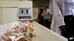FILE - A newly mechanized pharmaceutical machine that helps pharmacists dispense medicine is loaded with ARV medication, at the U.S. sponsored Themba Lethu, HIV/AIDS Clinic, at the Helen Joseph hospital, in Johannesburg, South Africa.