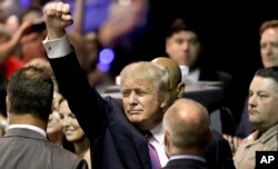Republican presidential candidate Donald Trump raises his arm as he leaves after a rally in The Woodlands, Texas, June 17, 2016.