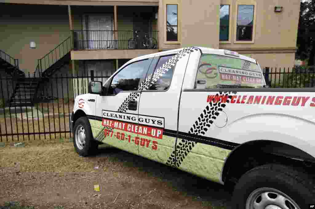 A hazardous materials cleaning company truck sits parked outside The Ivy Apartments, Oct. 2, 2014, in Dallas.