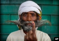 An Indian displays indelible ink mark on his index finger after casting his vote in the seventh and final phase of national elections, on the outskirts of Varanasi, India, May 19, 2019.