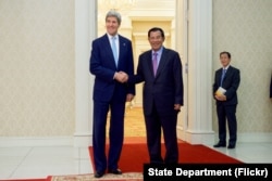 U.S. Secretary of State John Kerry poses for photographers with Cambodian Prime Minister Hun Sen before a bilateral meeting on Jan. 26, 2016, at the Peace Palace in Phnom Penh, Cambodia.