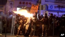Polisi anti huru-hara Hong Kong menembakkan gas air mata untuk membubarkan aksi demonstrasi hari Minggu (20/10). 