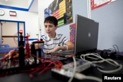 FILE - A student works on his robot at Escuela Vieau Middle School in Milwaukee, Wisconsin.