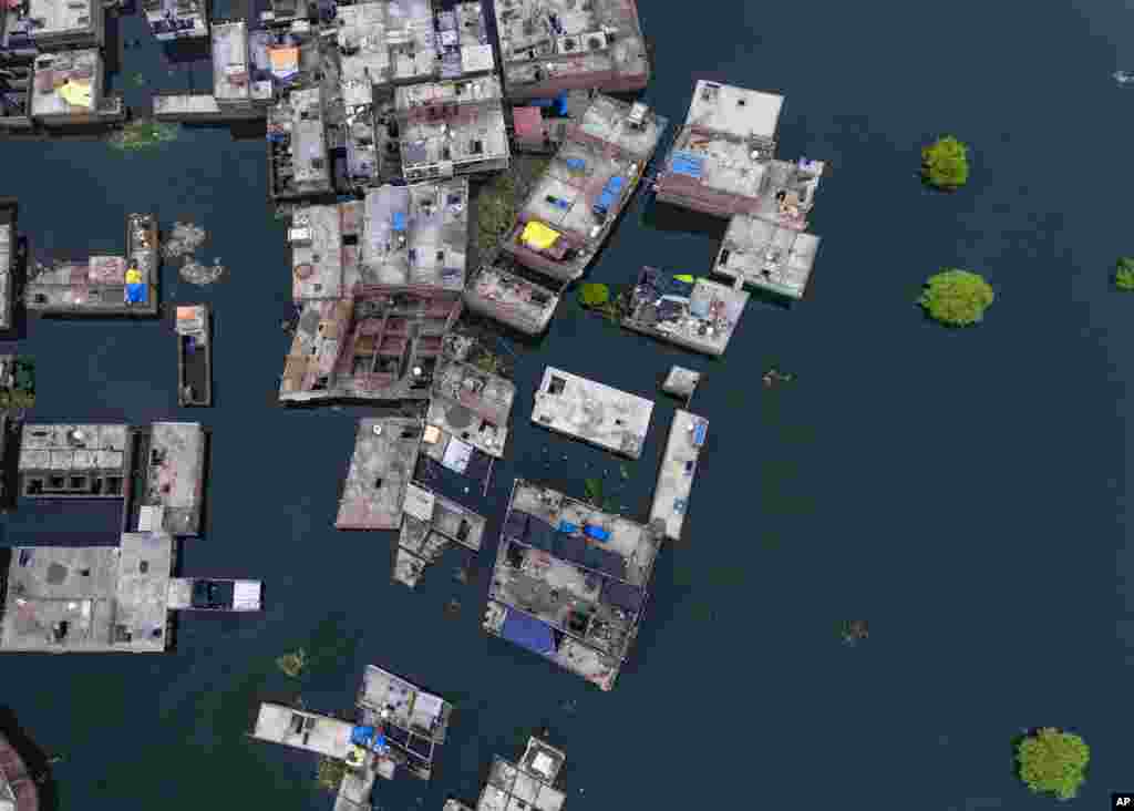 Floodwaters surround the houses by the River Ganges in Prayagraj, India. Heavy monsoon rains have raised the water level of the Ganges River above the danger level, triggering evacuation of thousands of people from flooded homes around the area.