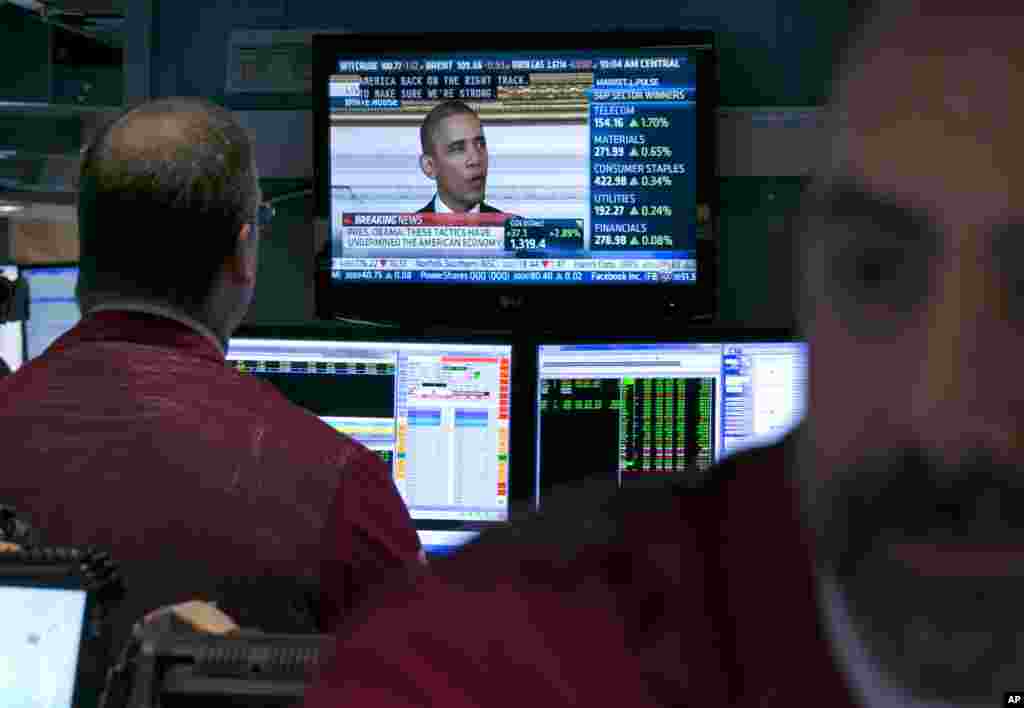 Pres. Barack Obama, speaking in Washington, D.C., is seen on a screen on the floor of the N.Y. Stock Exchange, Oct. 17, 2013. Obama says the government shutdown "inflicted unnecessary damage" to the U.S. economy.