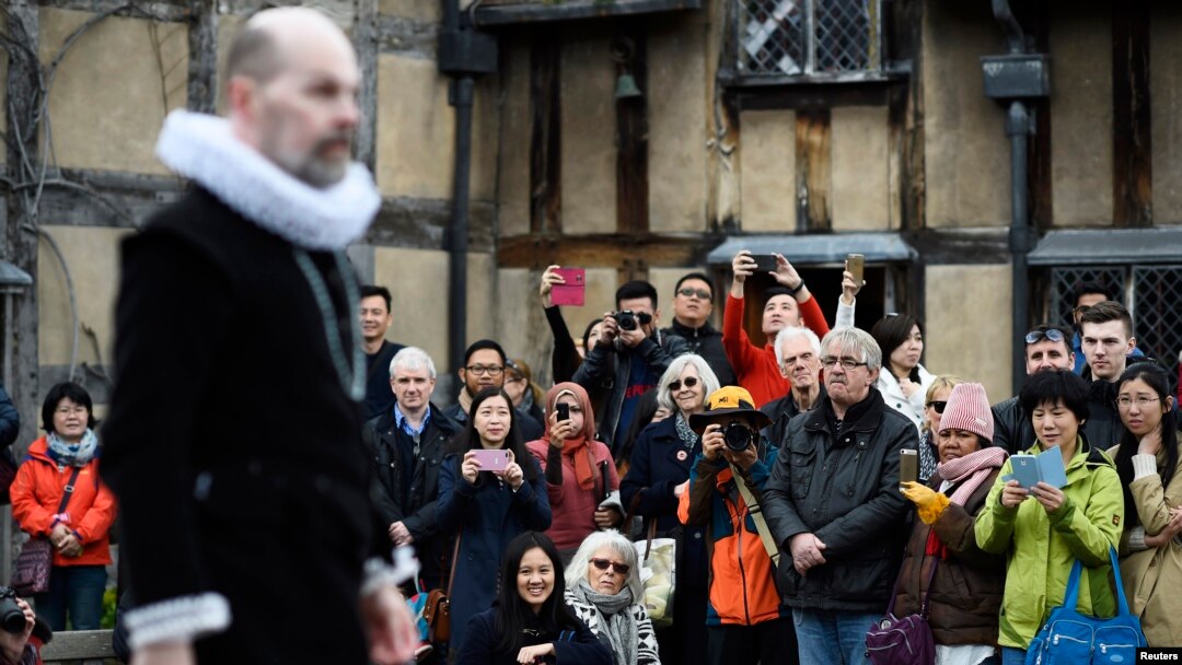 Para turis menonton pertunjukan drama oleh para seniman di sebuah rumah di mana William Shakespeare dilahirkan di Stratford-Upon-Avon, Inggris pada acara hari Sabtu (23/4).