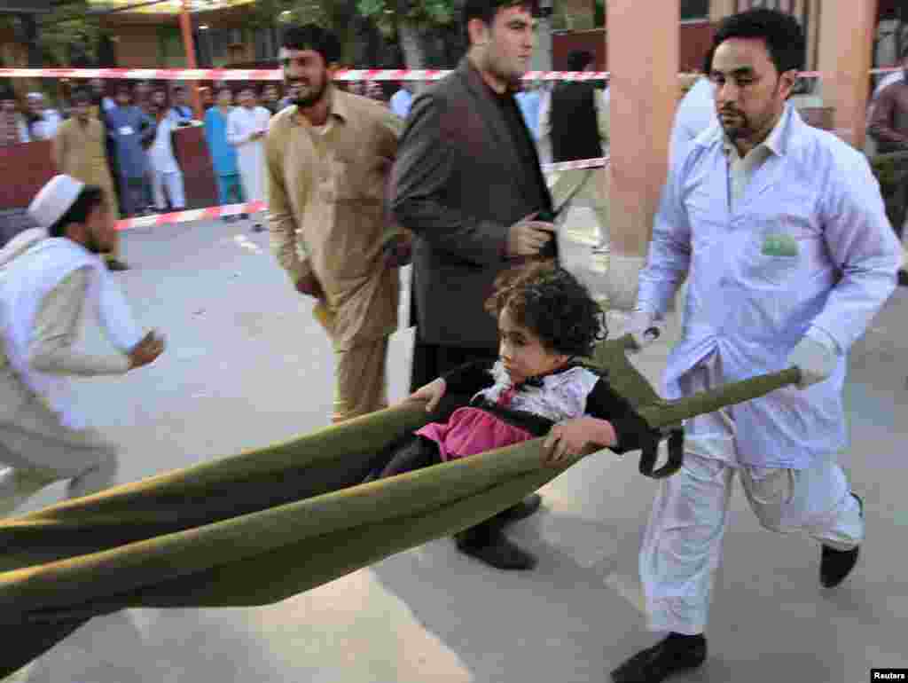 Rescue workers carry a young girl who was injured furing an earthquake in northern Afghanistan, at a hospital in Jalalabad, Afghanistan, Oct. 26, 2015.