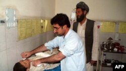  A Pakistani paramedic treats an Afghan boy injured in a roadside bomb explosion in Afghanistan, at a hospital in Chaman, the border town of Pakistan, July 8, 2012.