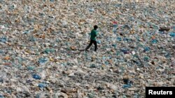 Dečak hoda kroz otpad i plastične kese u Karačiju u Pakistanu, 22. aprila 2020.