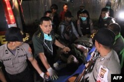 Petugas kepolisian dan tim medis merawat seorang anggota Brimob, yang tertembak dalam tembak menembak dengan kaum pemberontak separatis, di sebuah rumah sakit di Wamena, 5 Desember 2018