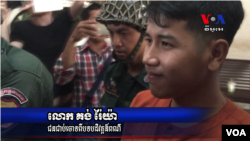 Kong Raiya is escorted by police officers after the Municipal Court of Phnom Penh sentenced him to one and a half year in prison, on March 15, 2016 for a Facebook post calling for a regime change. (Pin Sisovann/ VOA Khmer)