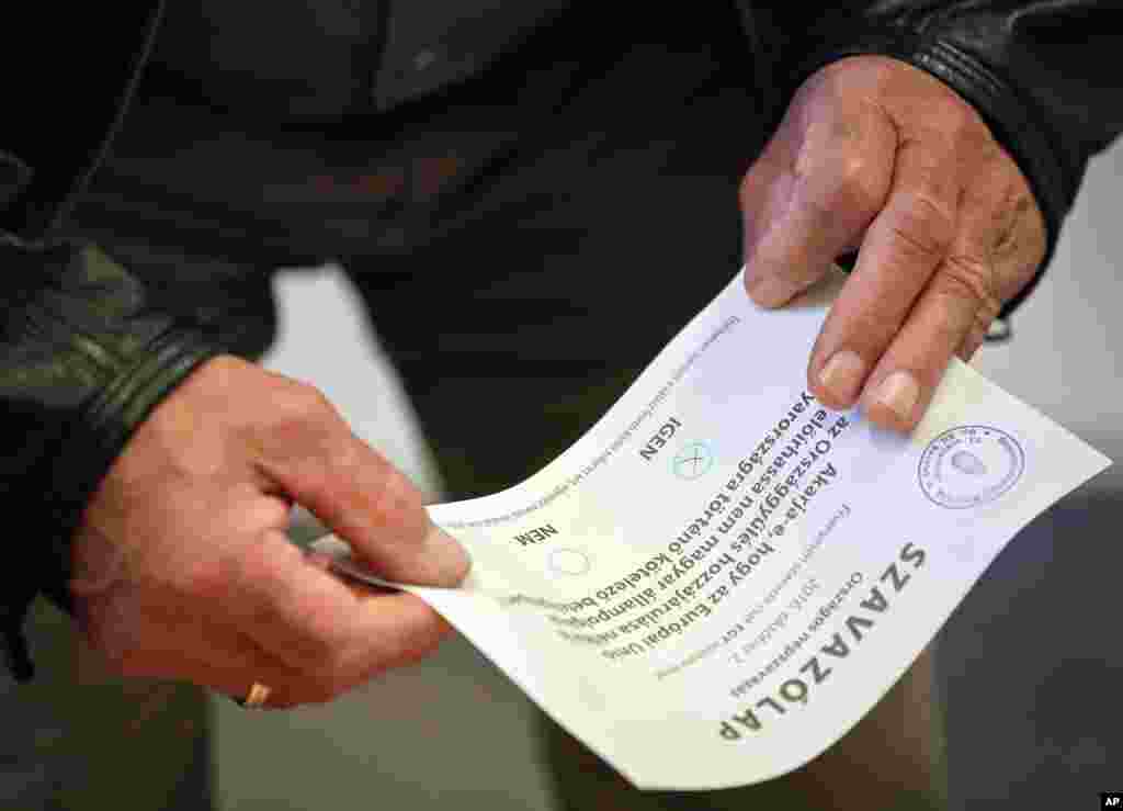 A man holds a ballot paper as he votes against Hungarian Prime Minister Viktor Orban&#39;s policies on migrants in the referendum, in Budapest, Oct. 2, 2016.