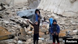 Des enfants jouent dans les ruines à Al-Rai, au nord d'Alep, en Syrie, le 25 décembre 2016.