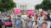 People hold up signs and photographs during a demonstration opposed to the White House policy that separated more than 2,300 children from their parents over the past several weeks in front of the White House in Washington, June 21, 2018.