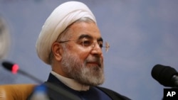 FILE - Iranian President Hassan Rouhani sits while attending the 27th International Islamic Unity Conference in Tehran, Iran, Jan. 17, 2014.
