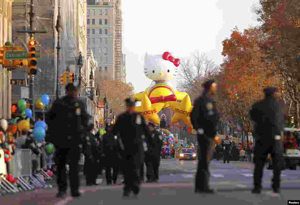 2012年11月22日，警察走在紐約中央公園西側，同時，Hello Kitty气球等待著梅西第86屆花車遊行開始。