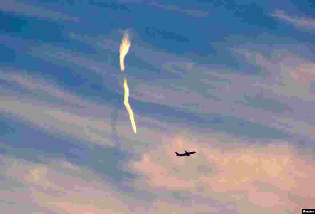 The trail of an aeroplane is seen after it took off from Sydney Airport, Australia.