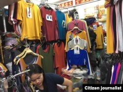 ຍິງ​ໜຸ່ມ​ລາວ​ຜູ້​ນຶ່ງ​ທີ່​ໄປ​ອອກແຮງ​ງານເປັນ​ຄົນ​ຊ່ວຍ​ຂາຍ​ເຄື່ອງ​ໃນ​ຮ້ານ​ຂາຍ​ເສື້ອ​ຜ້າ​ແຫ່ງ​ນຶ່ງ​ໃນ​ໄທ