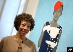 FILE - Amy Sherald, winner of the Outwin Boochever Portrait Competition 2016 first prize, stands in front of her work, March 11, 2016, at the Smithsonian's National Portrait Gallery in Washington D.C.