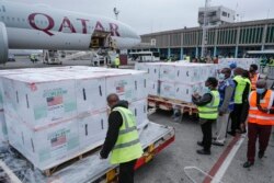 FILE - Officials receive boxes of Moderna coronavirus vaccine at the airport in Nairobi, Kenya, Sept. 6, 2021.