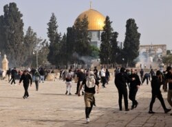 Warga Palestina berlarian setelah pasukan Israel menembakkan gas air mata pasca aksi protes di kompleks masjid Al Aqsa (10/5).