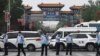中国警察在被关闭的北京新发地农产品批发市场的入口处站岗。（2020年6月13日）