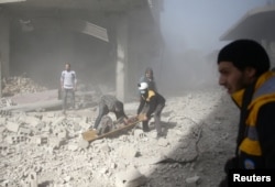 Civil defense members and civilians carry a wounded man in the town of Hamoria, Eastern Ghouta, near Damascus, Syria, Dec. 3, 2017.