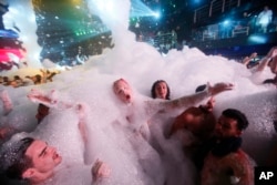 Spring Breakers are covered in foam at The City nightclub in the city of Cancun, Mexico, early Monday, March 16, 2015. Cancun continues to be one of the top foreign destinations for U.S. college students to spend Spring Break. (AP Photo)