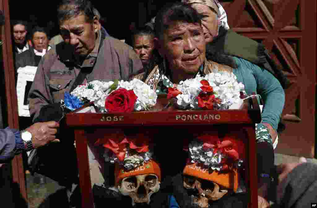 A woman carries decorated human skulls after praying in the chapel at the General Cemetery during the &quot;Natitas&quot; festival in La Paz, Bolivia.