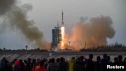 Shenzhou-11 manned spacecraft carrying astronauts Jing Haipeng and Chen Dong blasts off from the launchpad in Jiuquan, China (REUTERS)