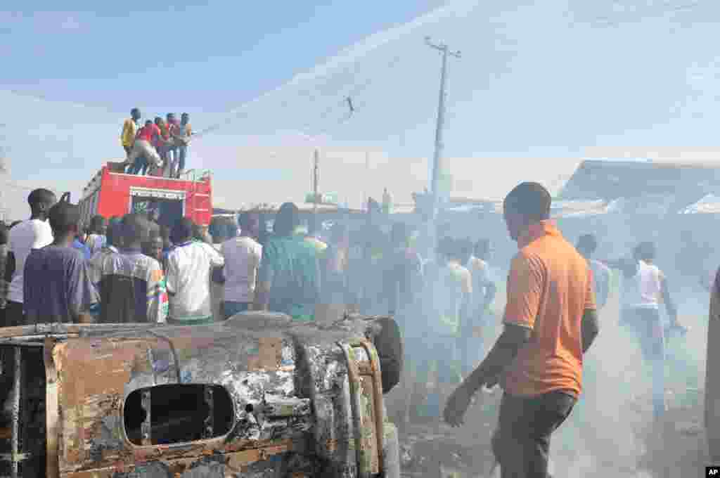 People gather at the scene of a car bomb explosion at the central market, Maiduguri, Nigeria, July 1, 2014. 