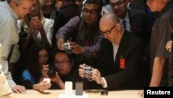 Miembros de los medios de comunicación fotografían el nuevo iPhone 5 en su presentación.