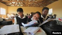 FILE - Children write notes from a makeshift blackboard at a school in Mwezeni village in South Africa's Eastern Cape Province, June 5, 2012. 