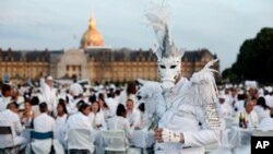 Participants dressed in white take part in the White Dinner, at the Invalides gardens, in Paris, Sunday, June 3, 2018.