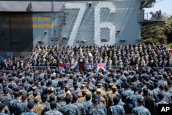 FILE - U.S. Vice President Mike Pence, center, speaks to U.S. servicemen and Japanese Self-Defense Forces personnel on the flight deck of U.S. navy nuclear-powered aircraft carrier USS Ronald Reagan, at the U.S. Navy's Yokosuka base in Yokosuka, south of Tokyo, April 19, 2017.