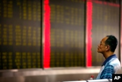 A Chinese investor monitors stock prices at a brokerage house in Beijing, Aug. 24, 2015.