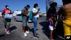 En esta fotografía de archivo del 20 de septiembre de 2021, los migrantes, muchos de ellos de Haití, suben a un autobús después de ser procesados y liberados después de pasar un tiempo en un campamento improvisado cerca del Puente Internacional en Del Rio, Texas, EE. UU.