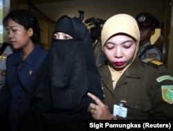 Petugas pengadilan mengawal Munfiatun (tengah), istri tersangka teror Malaysia, Noordin M. Top, setelah persidangannya di Bangil, Jawa Timur, 9 Juni 2005 (foto: ilustrasi).