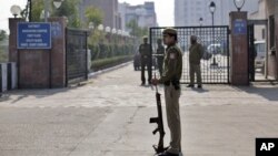 A Delhi policeman stands guard near the gate of a district court where the accused in a gang rape are undergoing trial, in New Delhi, India, January 24, 2013. 